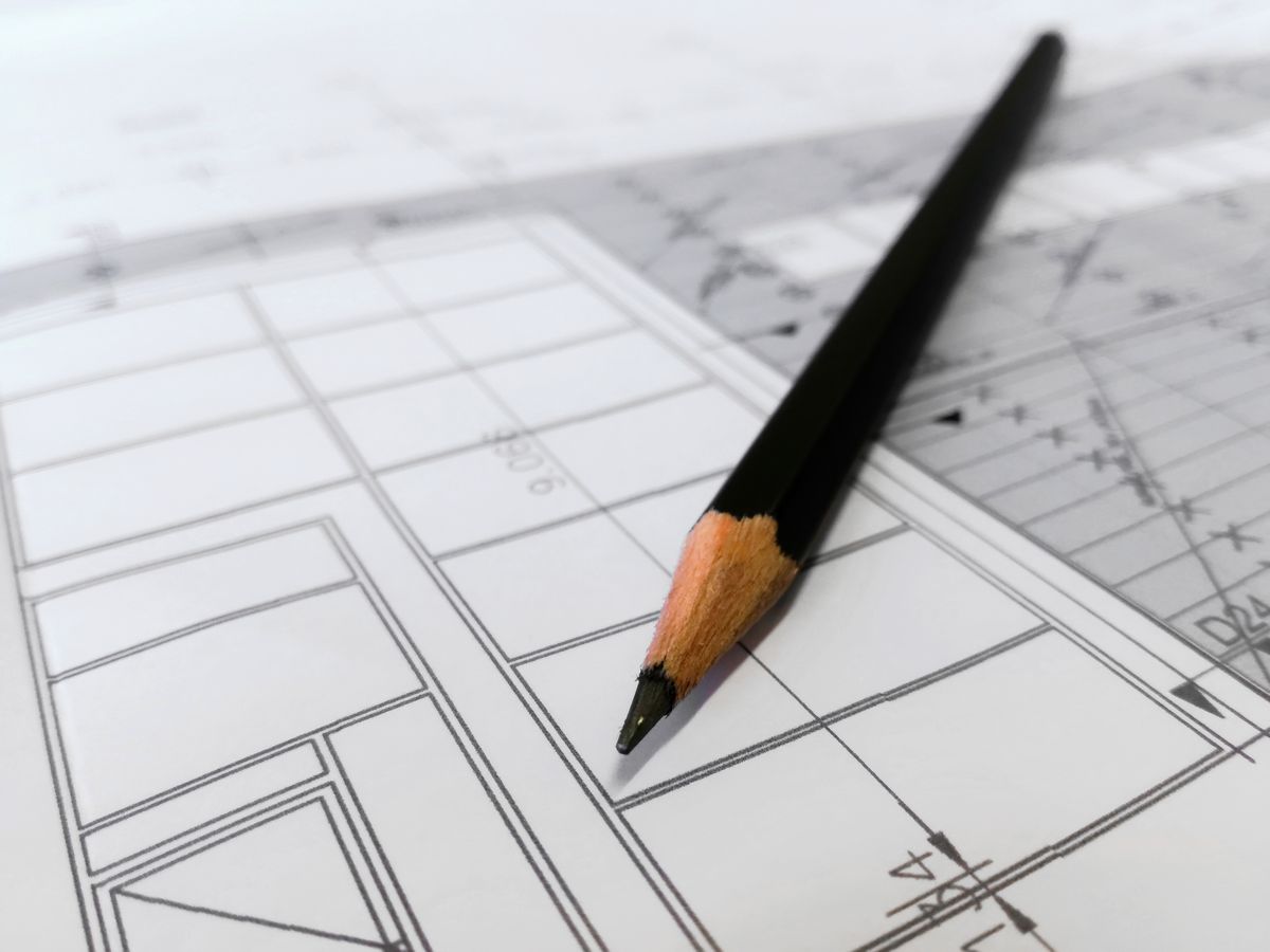 A pencil resting on architectural drawings under review